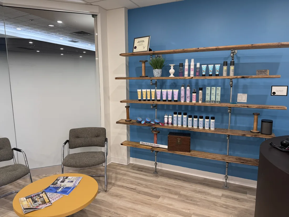 Waiting area with a blue product wall and wooden shelving